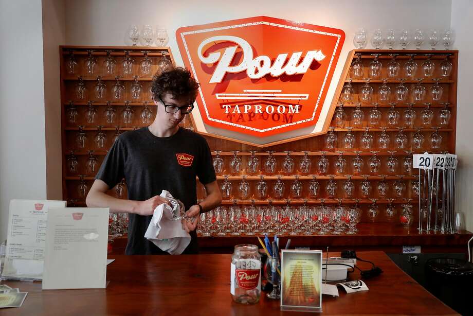 John Watson works the front desk and is also a server at pour-your-own Pour Taproom in Santa Cruz. Photo: Michael Macor, The Chronicle