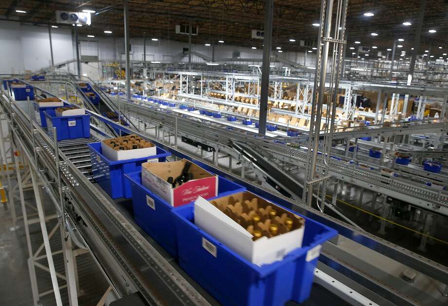 Blue bins containing cases of wine are transported by a network of conveyors for order fulfillment or restocking in the WineDirect warehouse in American Canyon. The new center ships tens of thousands of bottles of wine per day. Photo: Paul Chinn, The Chronicle