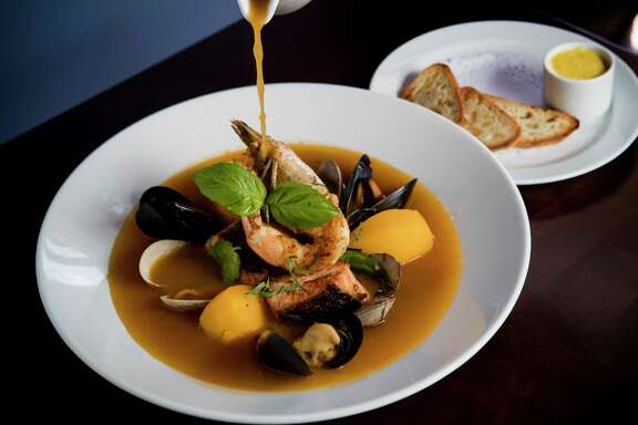 The broth with bouillabaisse is poured tableside at Maison Pucha Bistro.
